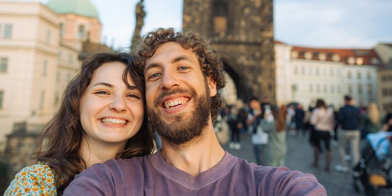 Een stel maakt een selfie op de Karelsbrug in Praag, Tsjechië, en legt zo de romantiek vast van een van de meest betoverende stedentrips van Europa.