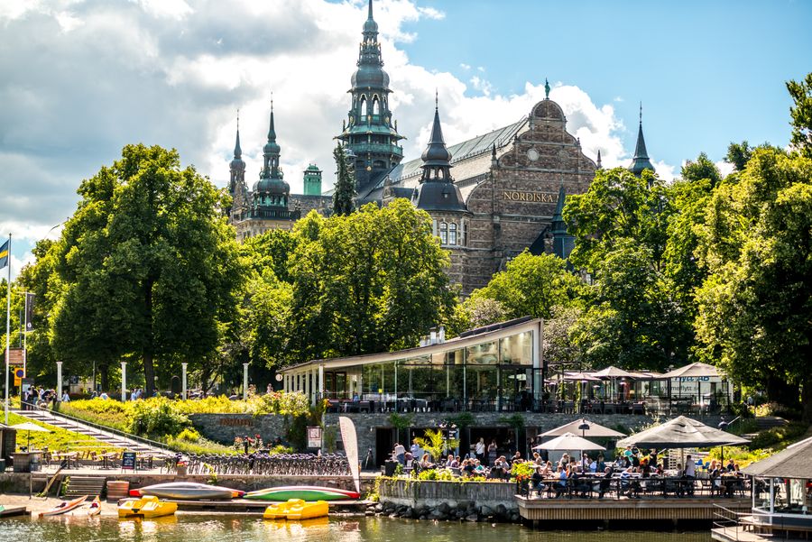  Een foto van het Nordiska-gebouw in Stockholm, met een café aan de rand van het water. 