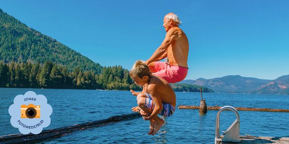 Oude man en jonge jongen springen in zee en leggen een vrolijk zomermoment vast voor de albelli Zomerfotowedstrijd.