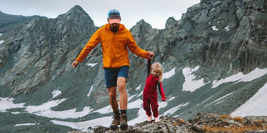 Een vader en dochter wandelen in een berglandschap, een voorbeeld van een long shot en de verschillende soorten shots in de fotografie bij albelli.
