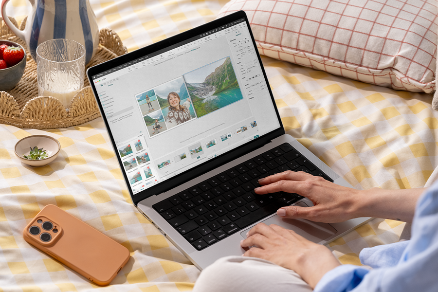 Iemand gebruikt de albelli fotoboek editor op een laptop in bed, als inspiratie voor makkelijk een fotoboek maken en een fotoalbum maker.