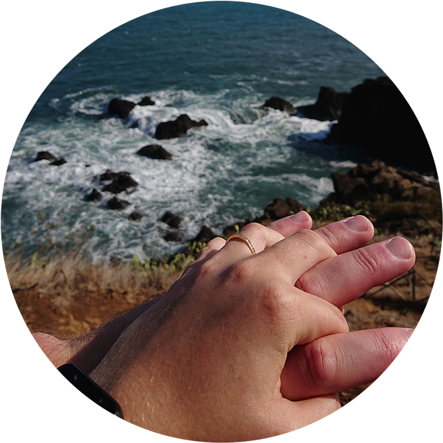 Twee handen verstrengeld aan zee op Madeira, waarvan één met een verlovingsring, als illustratie van Kamilla’s romantische aanzoekverhaal tijdens een vakantie.