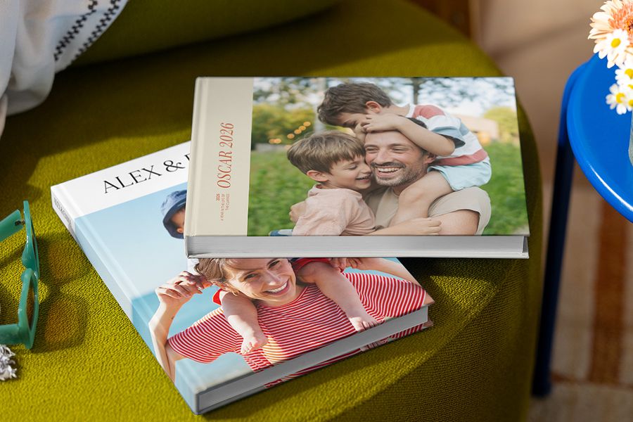 Twee verschillende albelli vakantie fotoboeken met familiefoto’s op de cover, waarop ouders, kinderen, een naam en het jaar te zien zijn, als illustratie van best practices voor het maken van een gepersonaliseerd reisfotoboek.