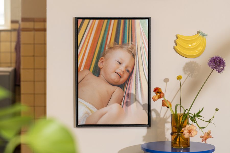 Gepersonaliseerde albelli wanddecoratie met een babyfoto naast bloemen en fruitdecoratie, als inspiratie voor vrolijke zomer decoratie in huis.
