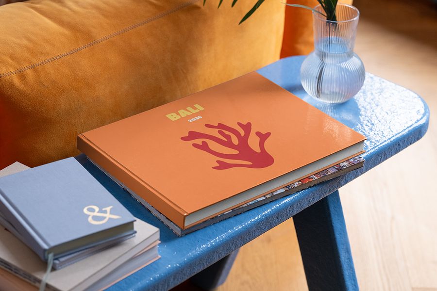 Een gepersonaliseerd liggend albelli reisfotoboek over Bali ligt op een blauwe salontafel, als inspiratie voor zomer decoratie woonkamer en zomerse styling op je salontafel.