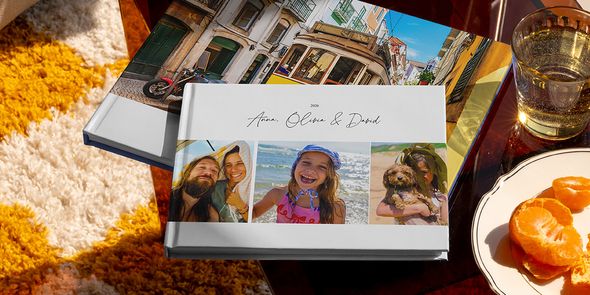 Twee verschillende albelli reisfotoboeken liggen samen in beeld, waaronder een liggend vakantie fotoboek met familiereisfoto’s op de cover en een ander met een vakantiefoto van een tram, als inspiratie voor verschillende soorten vakantie fotoboek maken.