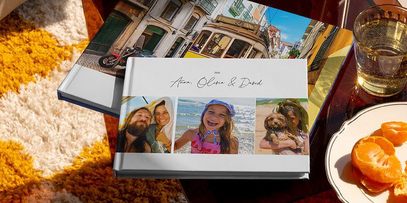 Twee verschillende albelli reisfotoboeken liggen samen in beeld, waaronder een liggend vakantie fotoboek met familiereisfoto’s op de cover en een ander met een vakantiefoto van een tram, als inspiratie voor verschillende soorten vakantie fotoboek maken.