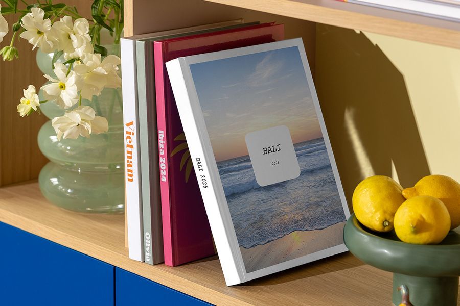 Het nieuwe Modern Travelogue fotoboek van albelli staat op een plank, met een strakke lay-out en elegante typografie geïnspireerd op reismagazines en koffietafelboeken.