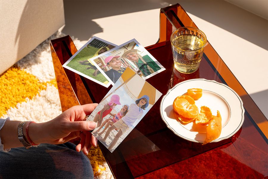 Iemand kijkt naar een selectie van prachtige fotoafdrukken, ter illustratie van hoe albelli kan helpen om georganiseerde foto's om te zetten in iets om te koesteren.