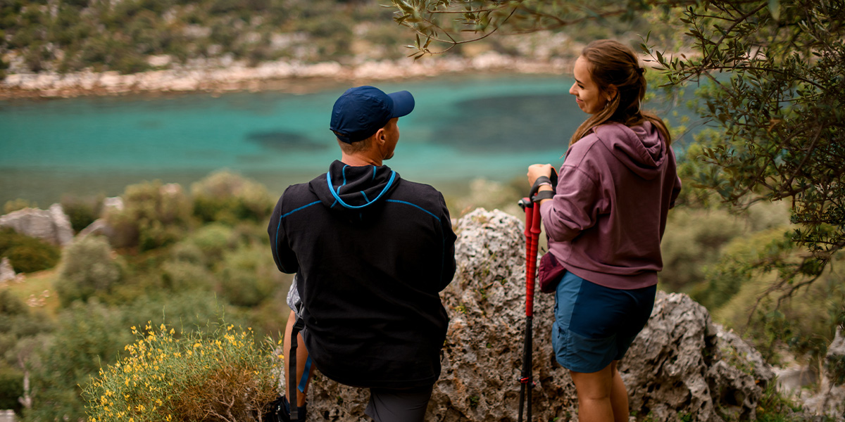 Een koppel staat in een prachtig natuurpark en kijkt uit over een blauw meer, als beeld van de natuurlijke schoonheid uit albelli's gids over de mooiste natuurparken van Europa.