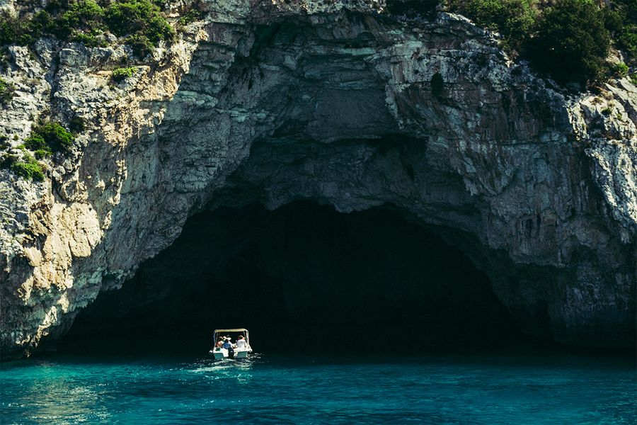 A boat enters sea caves in Corfu, capturing the slower pace and beauty of a Greek island September holiday.