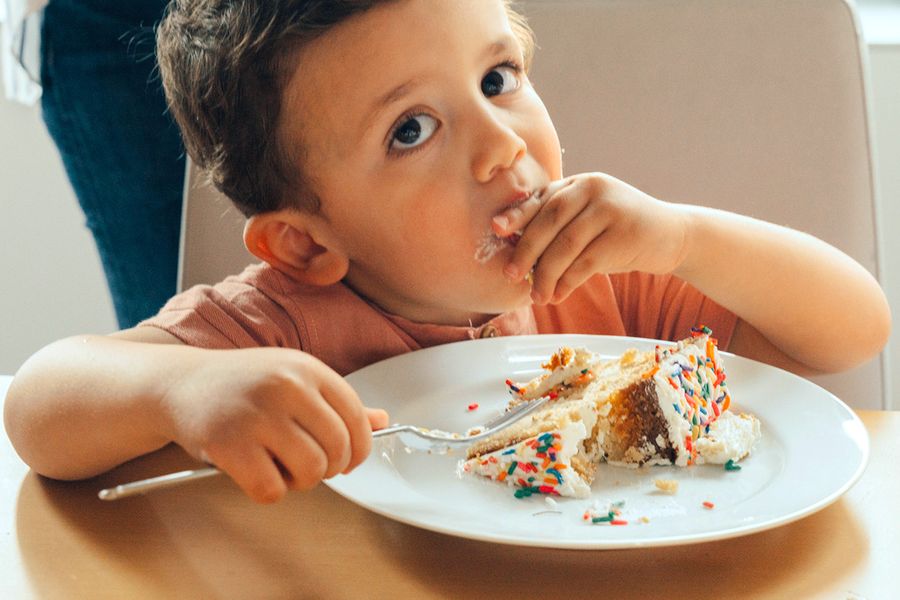 Een klein jongetje eet verjaardagstaart, ter illustratie van albelli's fotolijst om de beste momenten van een kinderverjaardagsfeestje vast te leggen.