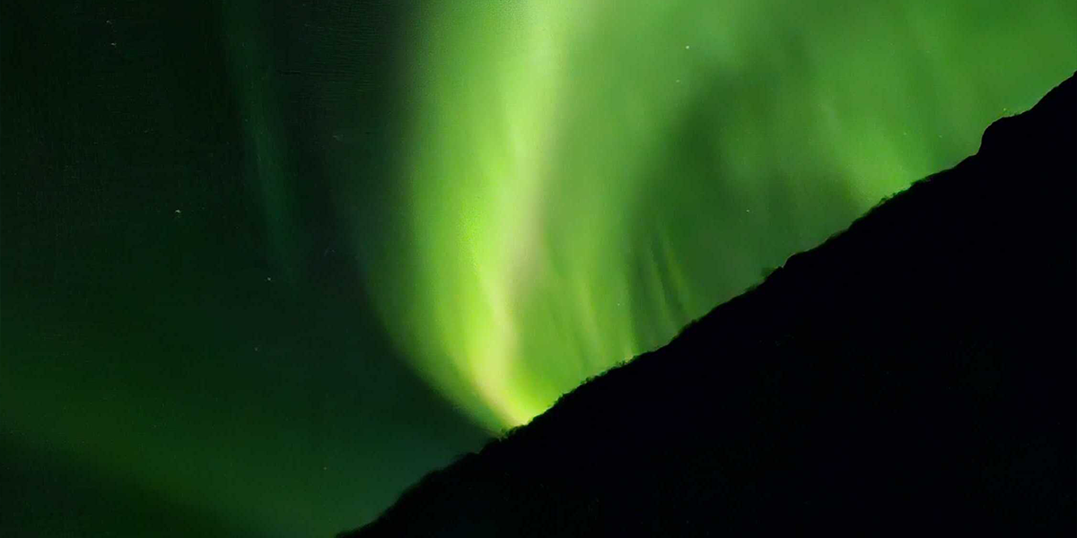 Noorderlicht aan de hemel in zeer groene kleuren, ter illustratie van albelli’s tips voor noorderlicht fotograferen.