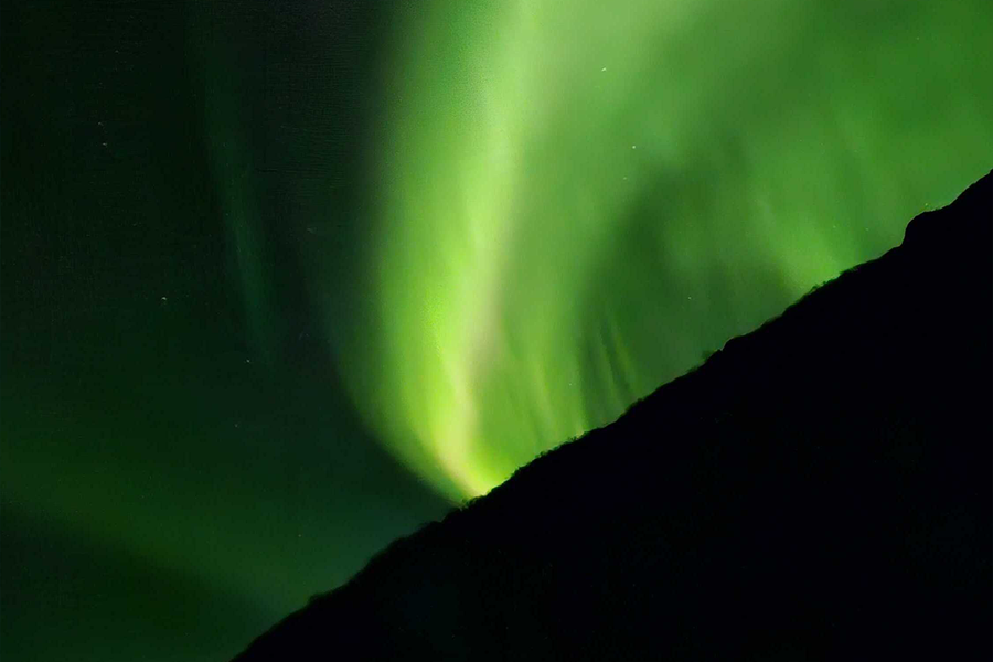 Noorderlicht aan de hemel in zeer groene kleuren, ter illustratie van albelli’s compositietips voor noorderlicht fotograferen.