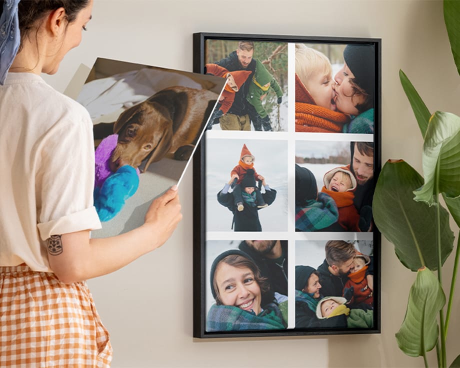 Een vrouw die glimlacht terwijl ze een wanddecoratie naast een collage op canvas vasthoudt.