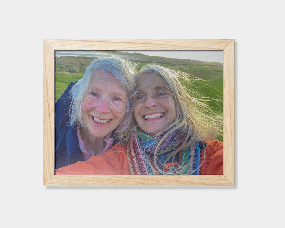 Een ingelijste poster met een foto van twee lachende vrouwen