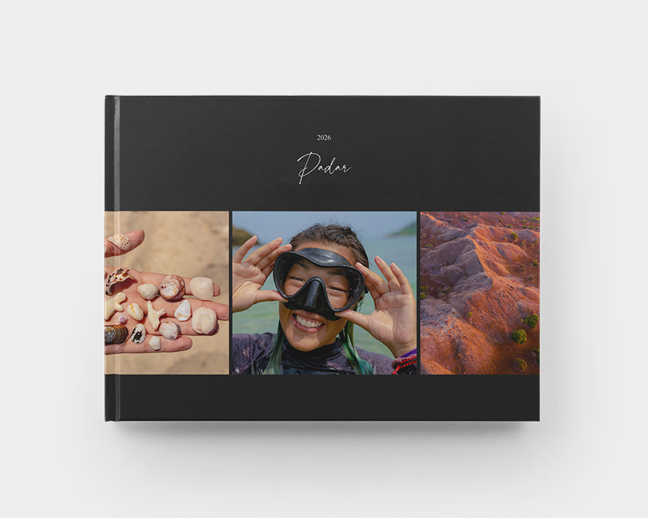 Een gesloten fotoboek met harde kaft in liggend formaat met zomerse foto's op de omslag