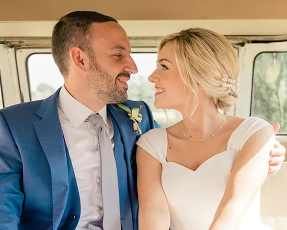 Fee, specialist in redactionele content bij albelli, en haar echtgenoot glimlachend in hun trouwauto, ter illustratie van een persoonlijk verhaal met tips voor de trouwplanning.